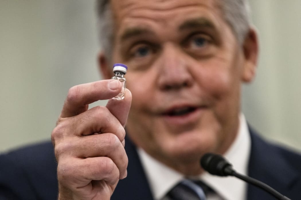 Wesley Wheeler, President of Global Healthcare at United Parcel Service (UPS), holds up a sample of the vial that will be used to transport the Pfizer COVID-19 vaccine at a Senate hearing in Washington