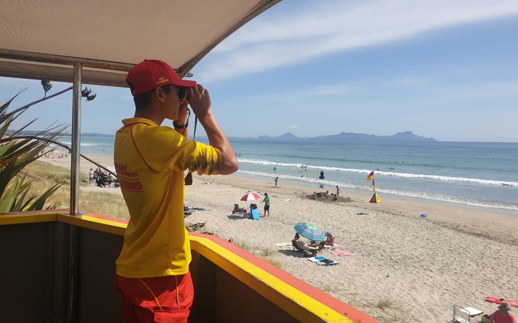 SLSNZ volunteer Surf Lifeguard with binoculars