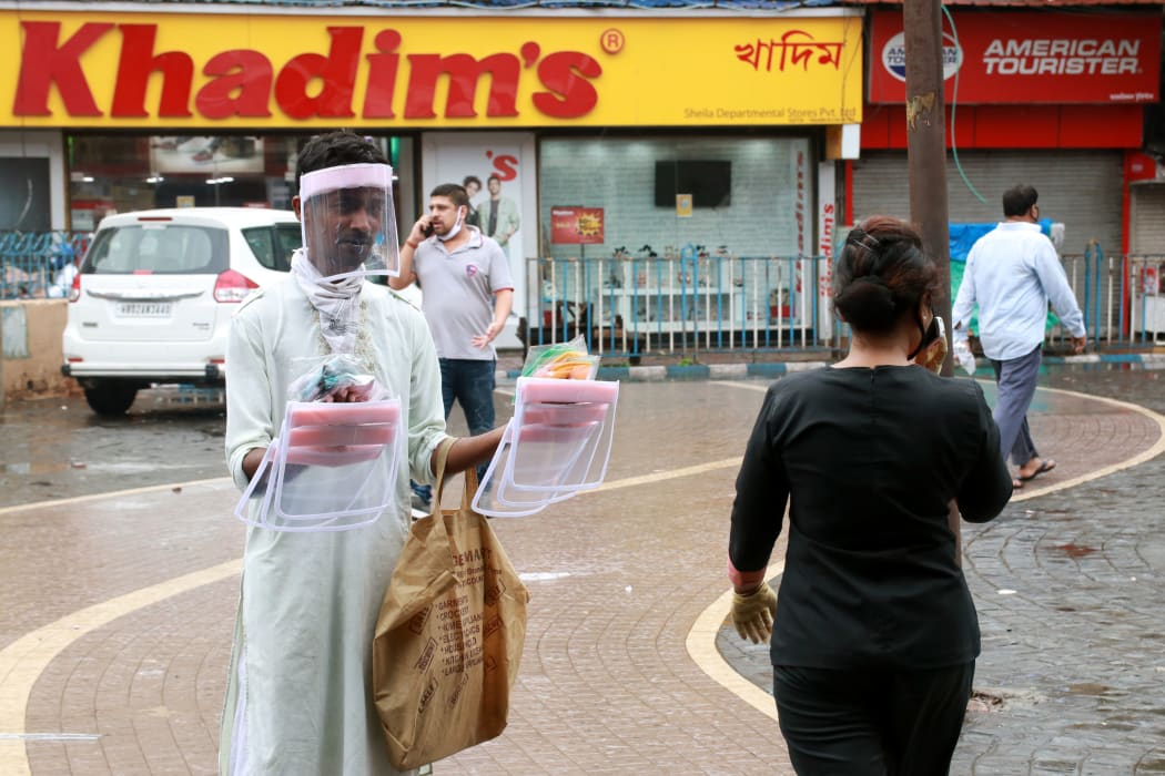 A hawker selling protective gear at a market place in Kolkata, India.
