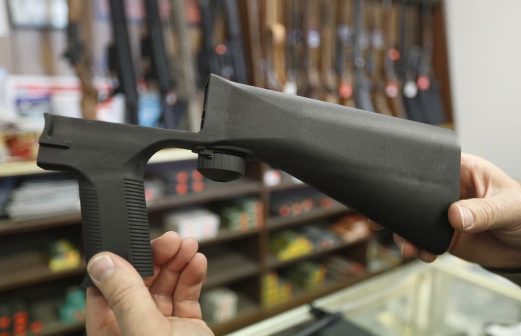 A bump stock device fits on a semi-automatic rifle to increase the firing speed.