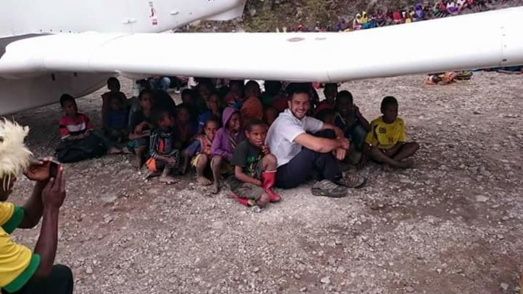 Tai sheltering under his aircraft with some local children