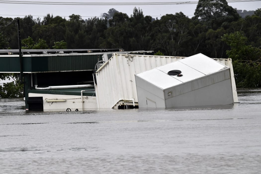 A container floats as rising floodwater inundated a commercial area during heavy rain in southwestern Sydney suburb of Camden on 8 March, 2022.