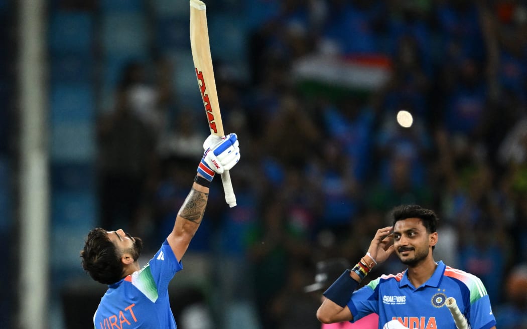 India's Virat Kohli celebrates with his teammate Axar Patel after scoring a century and their team's win at the end of the ICC Champions Trophy one-day international against Pakistan in Dubai, 23 Feb.