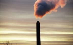 A plume of smoke rises out of an industrial chimney into the sky, in Copenhagen, Denmark.