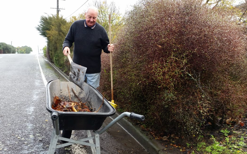 Kapiti resident Bob Taylor clears drains in case it floods again.