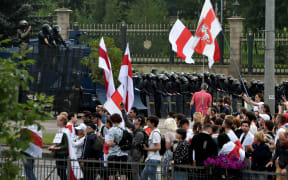 Demonstrators gather in front of law enforcement officers blocking an area in front of the Independence Palace.