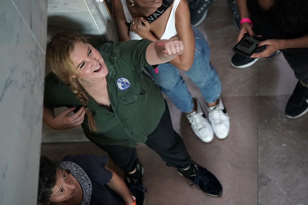 Comedian Amy Schumer waits to be led away after she was arrested during a protest against the confirmation of Supreme Court nominee Judge Brett Kavanaugh.