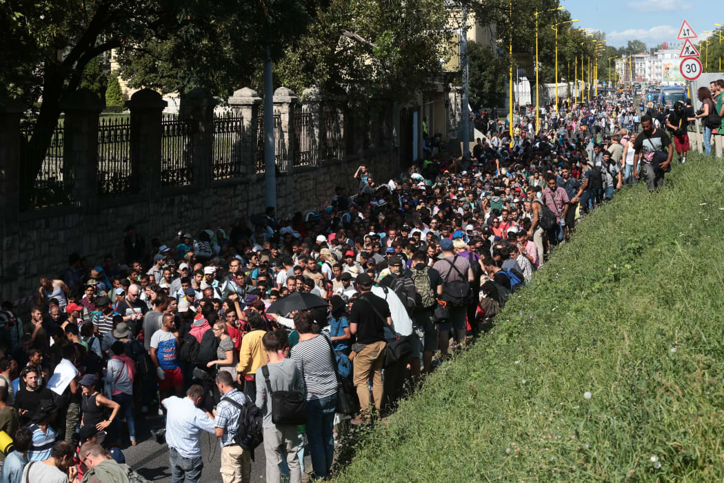 Hundreds of refugees and migrants - many from Syria - leave the transit zone of Budapest's main train staion for Austria on 4 September.
