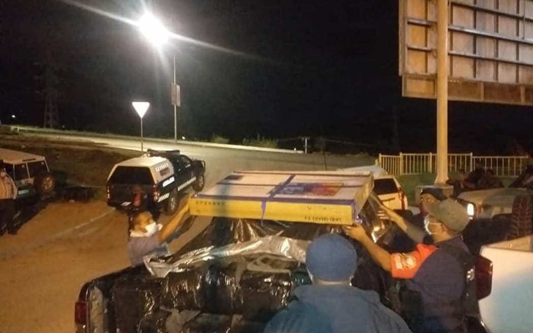 PNG police loading cartons of seized cocaine.