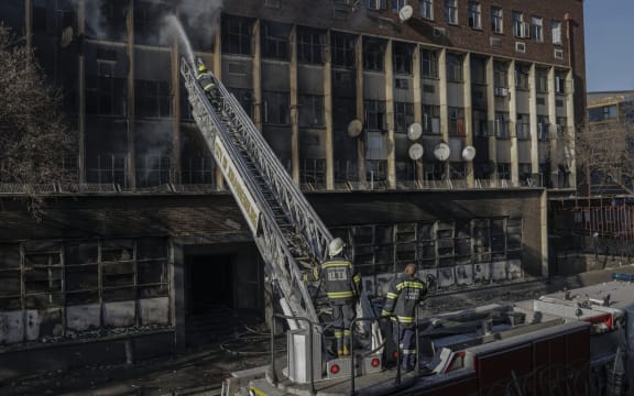 Firefighters extinguish a fire in a building in Johannesburg on 31 August, 2023. At least 20 people have died and more than 40 were injured in a fire that engulfed a five-storey building in central Johannesburg on August 31, 2023, the South African city's emergency services said.