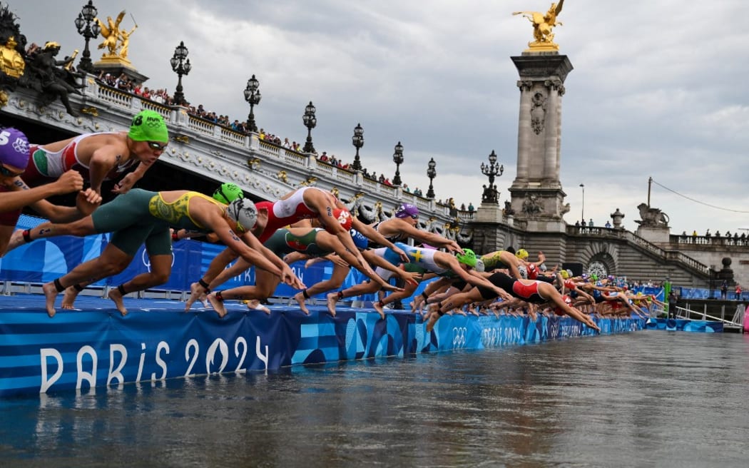 Athletes compete in the swimming race in the Seine during the women's individual triathlon at the Paris 2024 Olympic Games in central Paris on July 31, 2024. (Photo by Jeff PACHOUD / AFP)