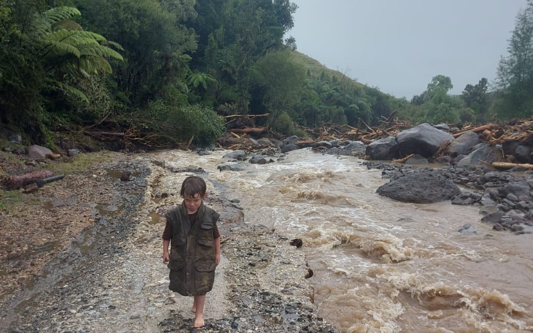 child walks along flood scoured road