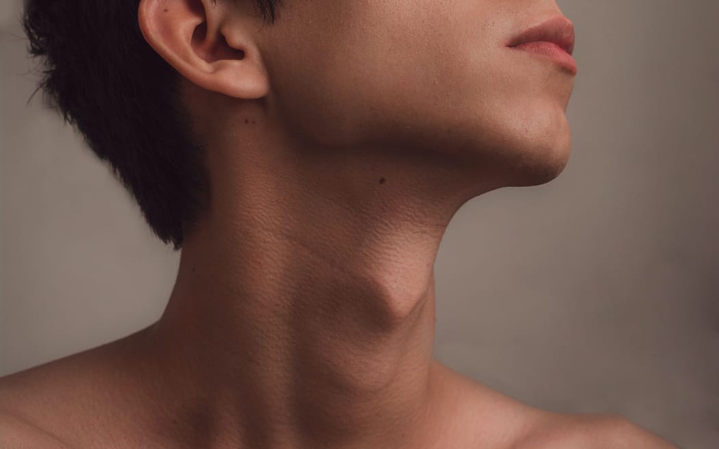 young man with head raised, exposing his bare neck