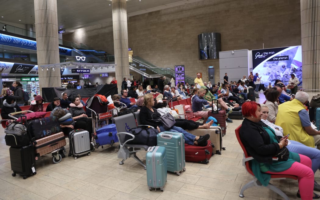 Passengers wait at Ben Gurion Airport near Tel Aviv, Israel, on October 7, 2023, as flights are canceled because of the Hamas surprise attack. The conflict sparked major disruption at Tel Aviv airport, with American Airlines, Emirates, Lufthansa and Ryanair among carriers with cancelled flights. (Photo by GIL COHEN-MAGEN / AFP)