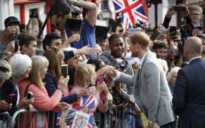 Prince Harry greets well-wishers on the street outside Windsor Castle ahead of marrying Meghan Markle.