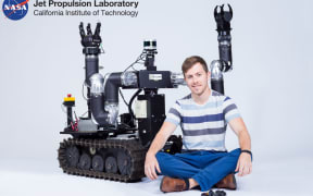 JPL Robotics Technologist Joseph Bowkett poses with RoMan.