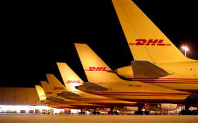 DHL cargo aircraft are unloaded at Leipzig/Halle Airport at night.