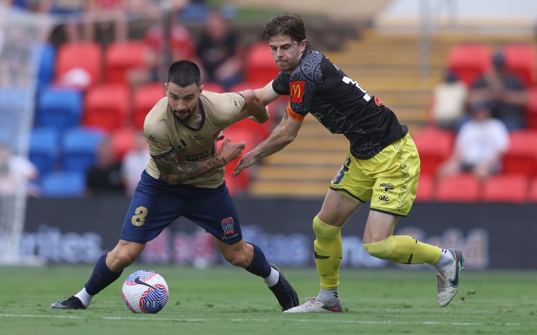 Apostolos Stamatelopoulos of the Jets competes for the ball with Alex Rufer of the Phoenix.