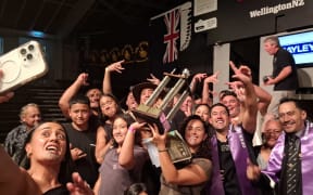 Toa Henderson swamped by whansu and friends after Saturday night's win.