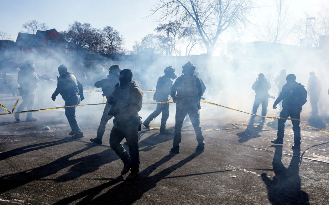 Federal agents gather amid tear gas during scuffles at the scene of a shooting involving federal immigration agents in Minneapolis on January 24.