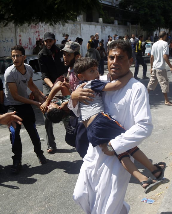 Injured people are carried from the scene of an Israeli strike on a UN school in Rafah.