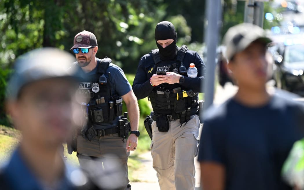 Bureau of Alcohol, Tobacco, Firearms and Explosives (ATF) agents survey the scene following a mass shooting at Annunciation Catholic Church on August 27, 2025 in Minneapolis, Minnesota.