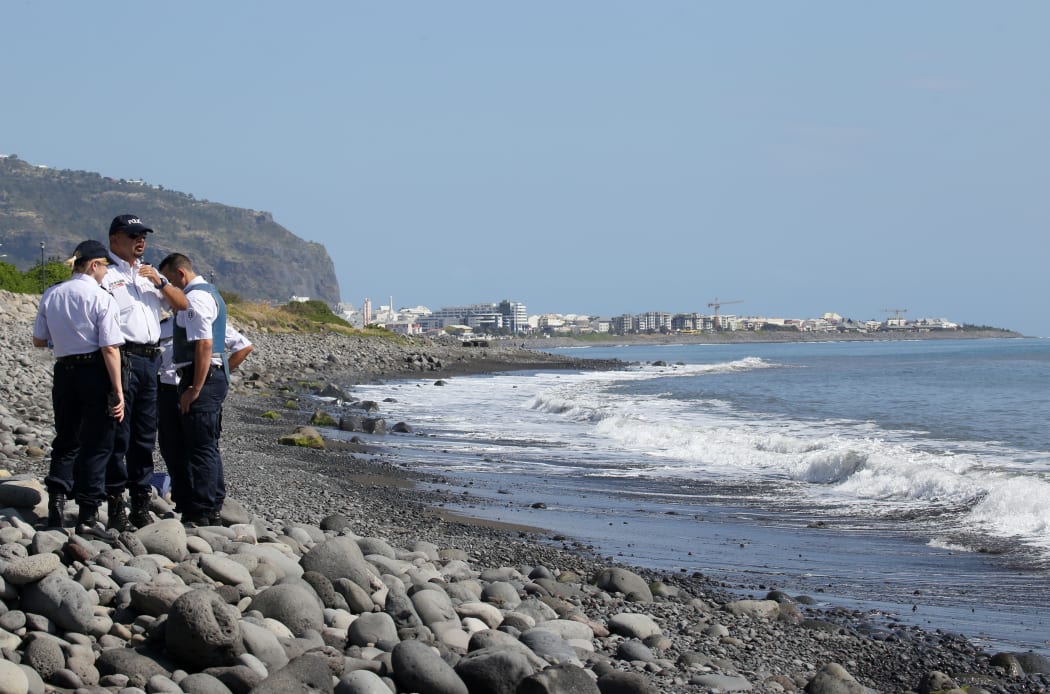 Police officers inspect metallic debris on the French Reunion Island in the Indian Ocean.