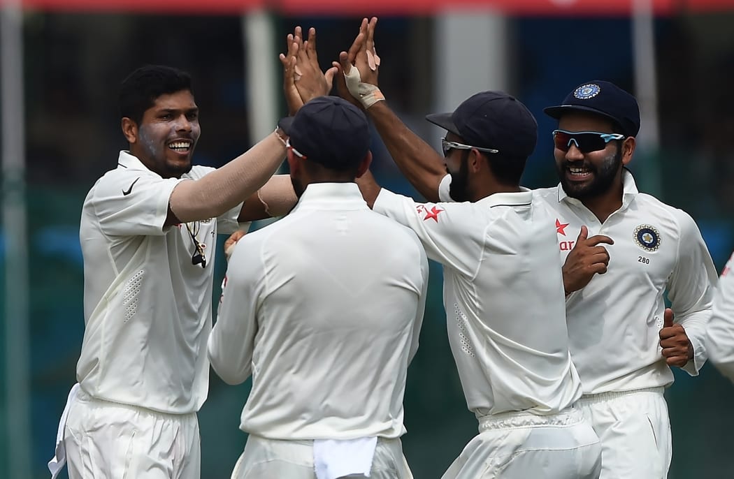 India's Umesh Yadav, left, celebrates the wicket of New Zealand's Martin Guptill with teammates during the second day of the first Test at Green Park Stadium in Kanpur on 23 September 2016.