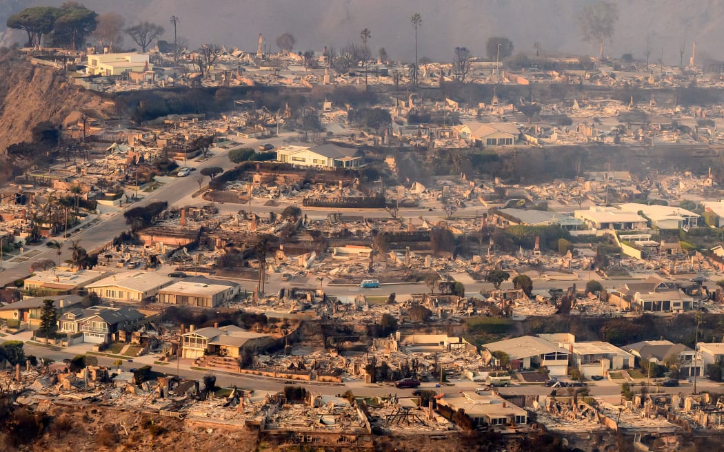 In this aerial view taken from a helicopter, burned homes are seen from above during the Palisades fire near the Pacific Palisades neighborhood of Los Angeles, California on 9 January 2025.