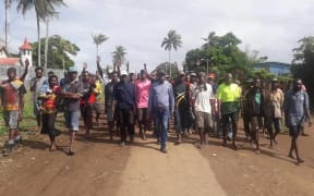 Samuel Winggu (centre) leading people in Daru.