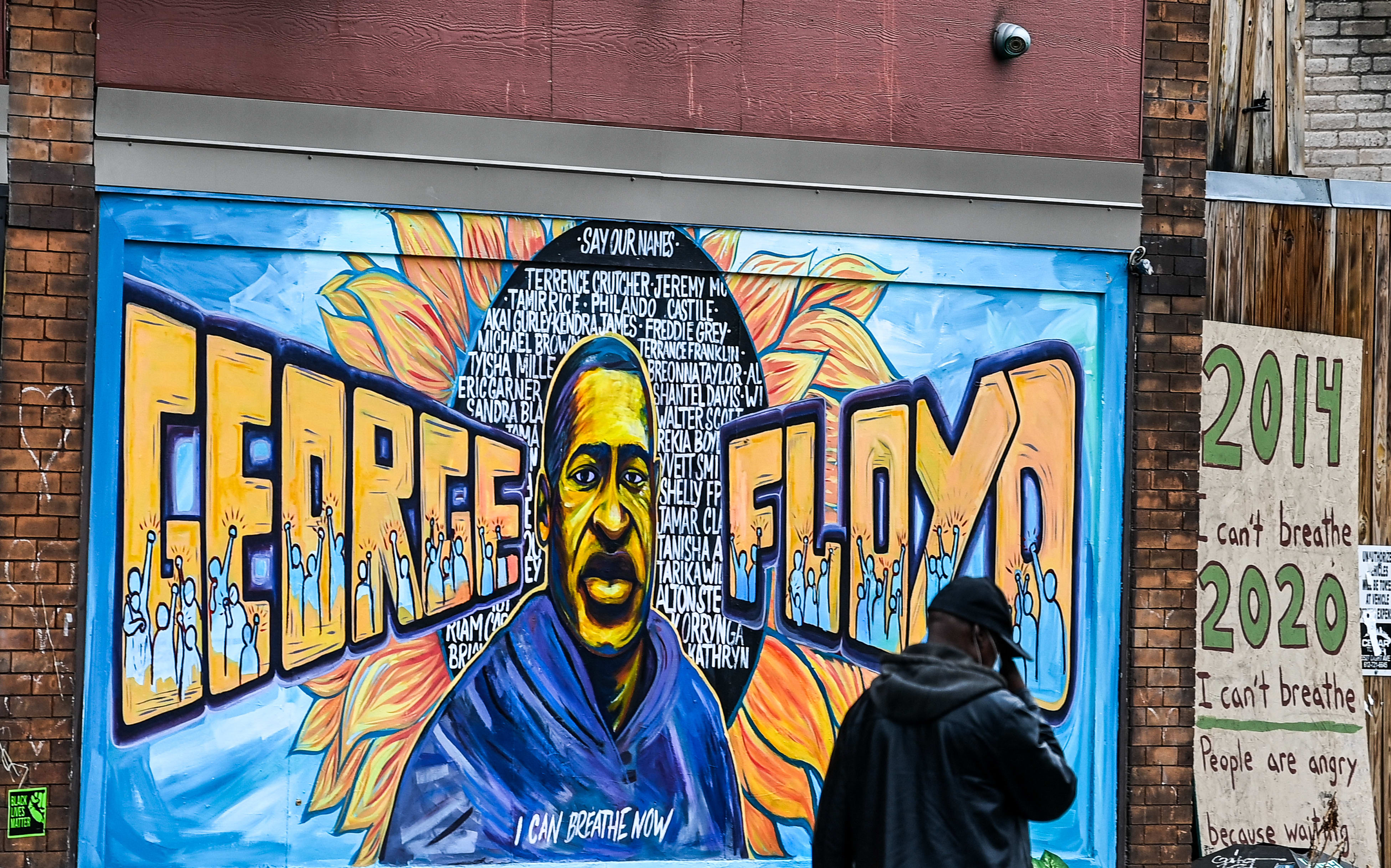 A man walks past the mural of George Floyd in Minnesota.