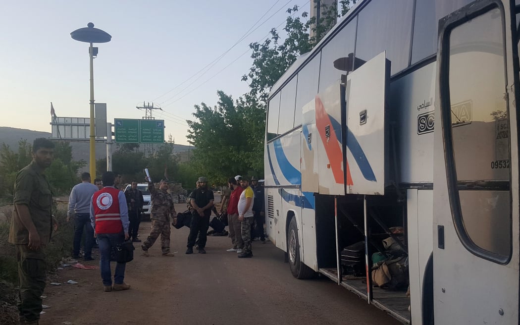 Syrians prepare to board as bus to leave the besieged town of Madaya, on 20 April.