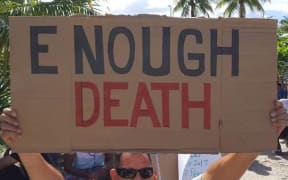 A Manus Island detainee holds a placard during the 81st day of protest.