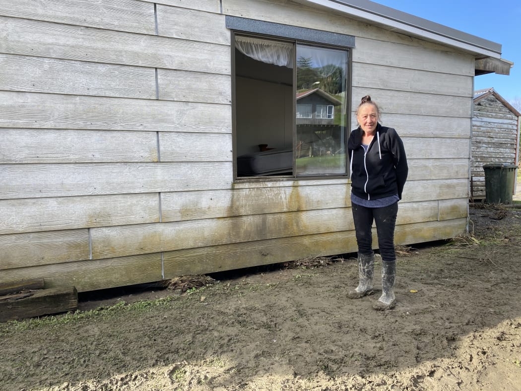 Jan Whaitiri at the window of her brother's house, where floodwater was rushing through.