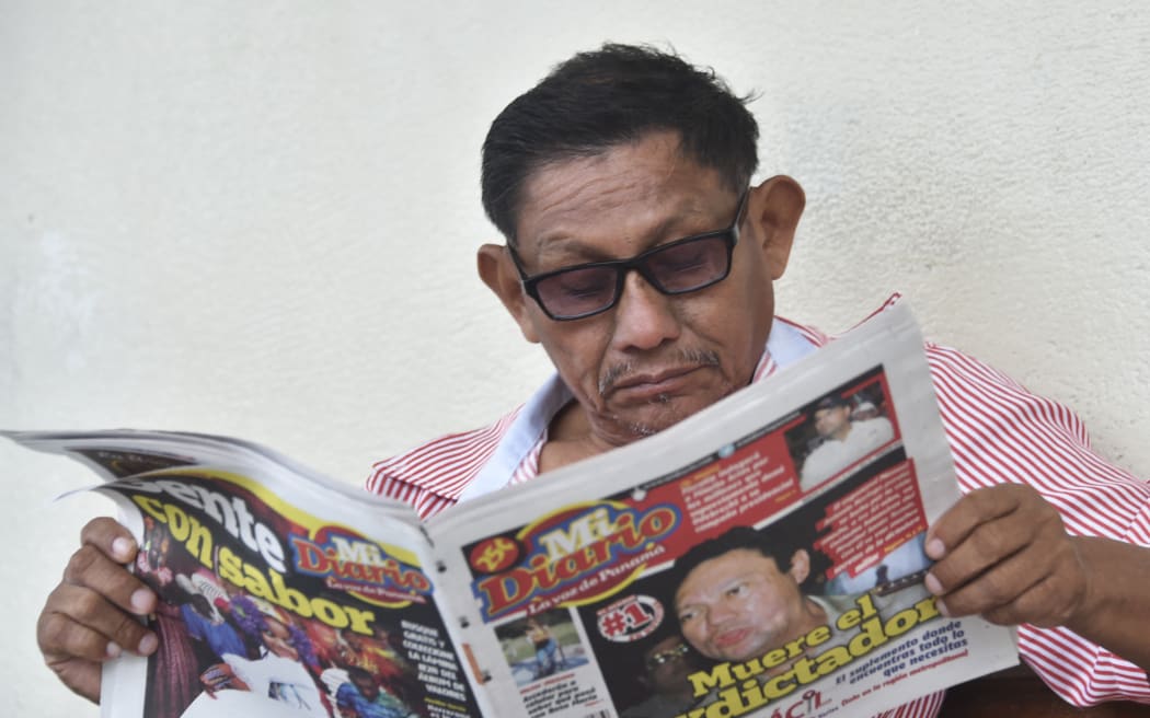 A man reads a newspaper which announces Manuel Antonio Noriega decease on May 30, 2017 outside Santo Tomas Hospital in Panama City. Manuel Antonio Noriega, who took power in Panama in 1983 and was ousted by US forces in 1989, died late Monday, May 29, 2017 in Panama City, a government official said. (Photo by RODRIGO ARANGUA / AFP)