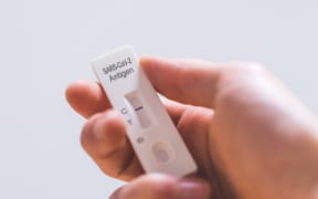 Close up of fingers holding express antigen covid test, negative result
