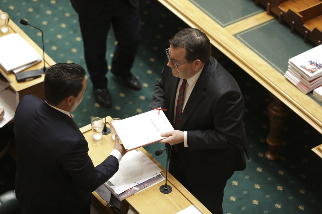 Finance Minister Grant Robertson hands the Budget document to National Party leader Simon Bridges in Parliament 30 May 2019.