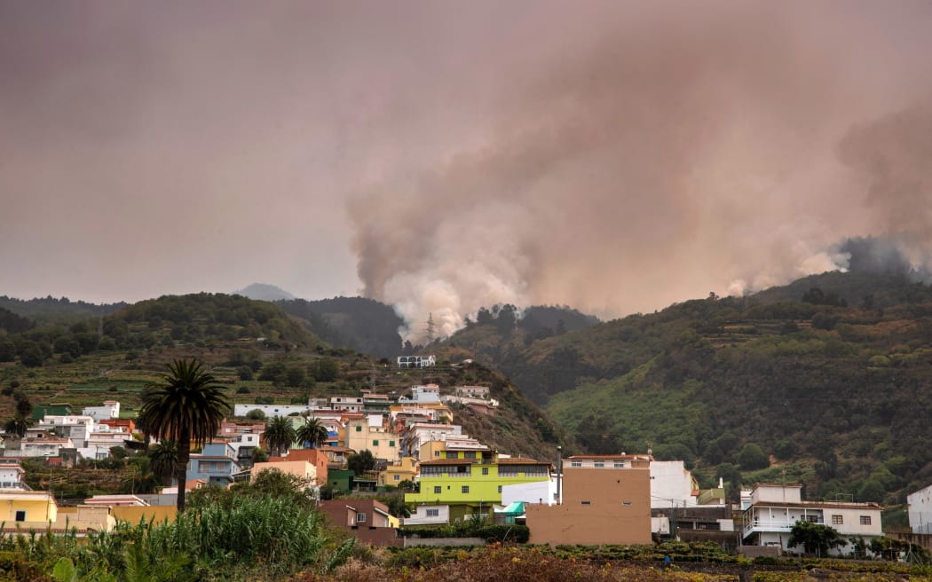 A wildfire rages out of control through forested slopes in La Matanza on the Canary island of Tenerife on August 19, 2023. More than 26,000 people may have been forced to flee a vast wildfire raging out of control in the Spanish holiday island of Tenerife, the emergency services said today. The huge blaze, which broke out late Tuesday in a mountainous northeastern area of the island, is the "most complex fire" to hit Spain's Atlantic Canary Islands in more than 40 years, the authorities say. (Photo by DESIREE MARTIN / AFP)
