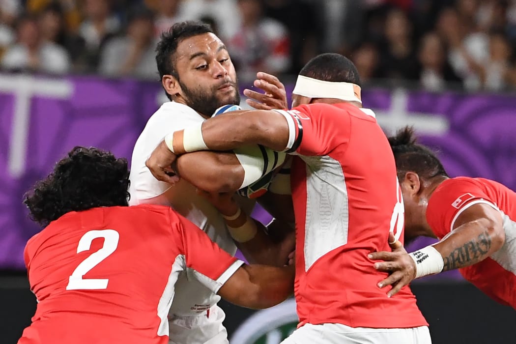 England number 8 Billy Vunipola is tackled by Tonga's Sefo Sakalia and Maama Vaipulu.