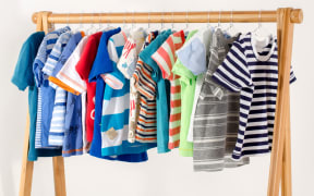 Children's clothing arranged on hangers.