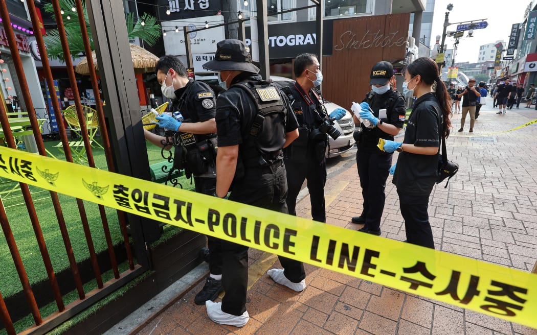 Police officers investigate the scene of an attack near the Sillim subway station in southwest Seoul on July 21, 2023. One person was killed and three more wounded when a man went on a "stabbing rampage" near a subway station in the South Korean capital Seoul on July 21, police told AFP. (Photo by YONHAP / AFP) / - South Korea OUT / NO ARCHIVES -  RESTRICTED TO SUBSCRIPTION USE