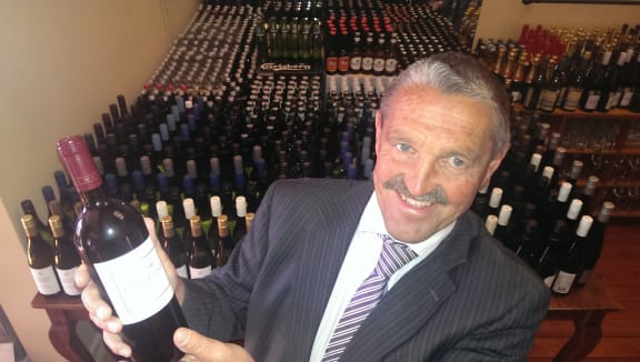 Bruce Richards with the extensive wine collection for sale.