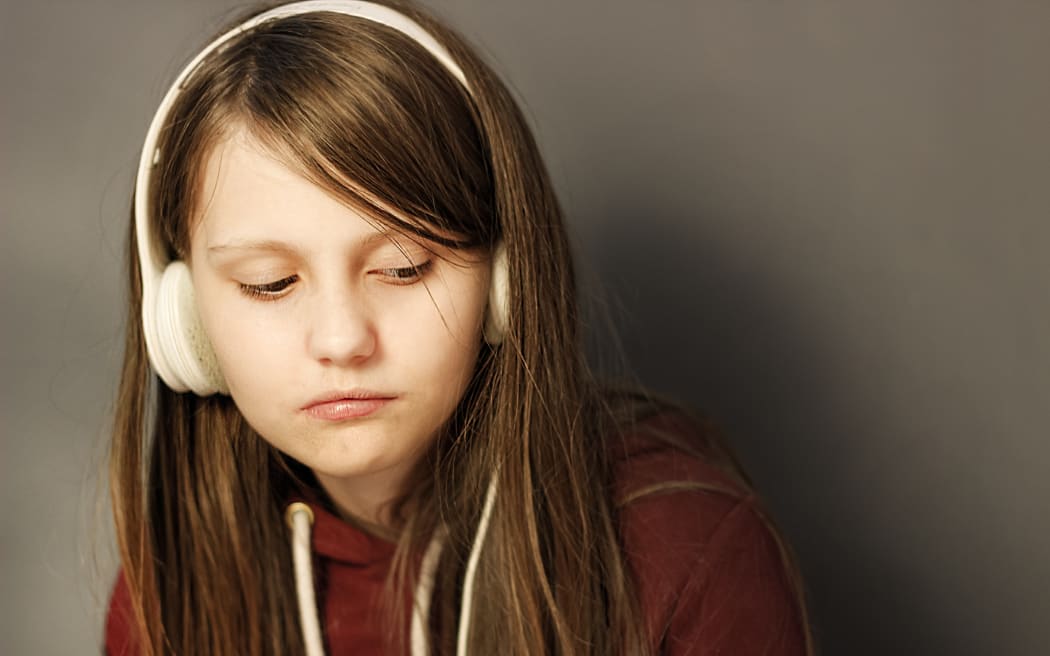 Bored tween wearing headphones