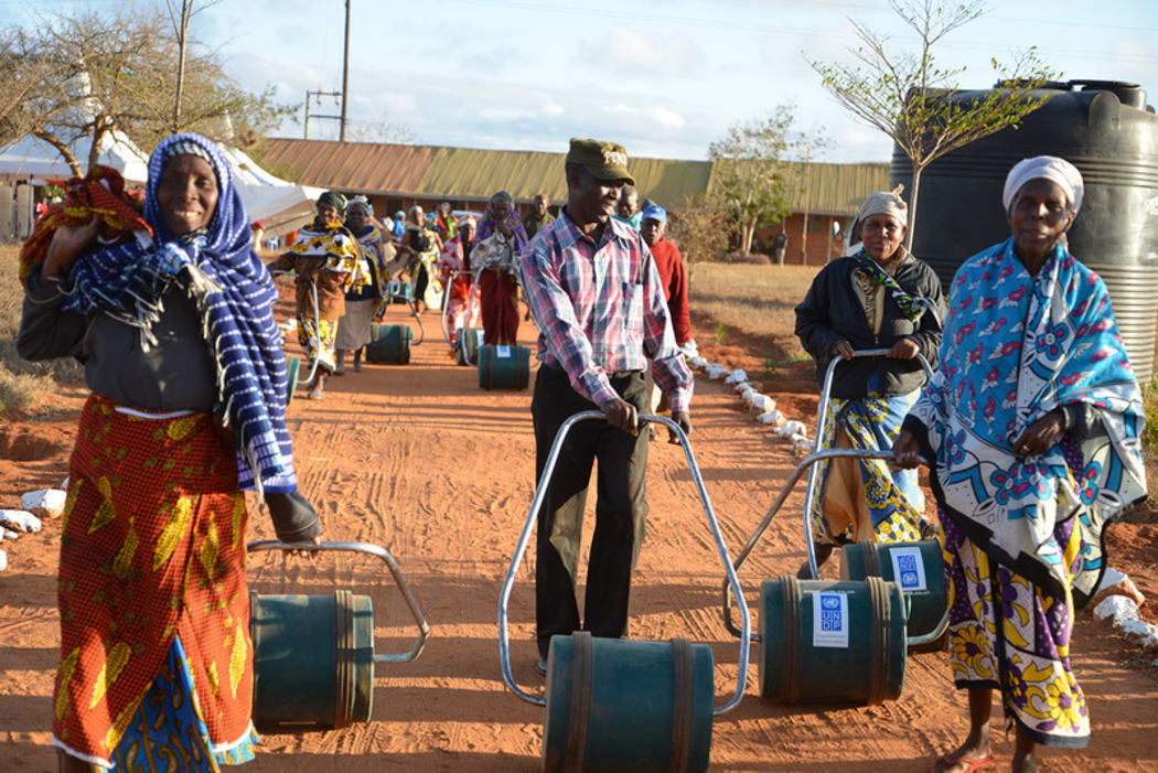 A group of Roll Out The Barrel recipients with their community's new water containers.