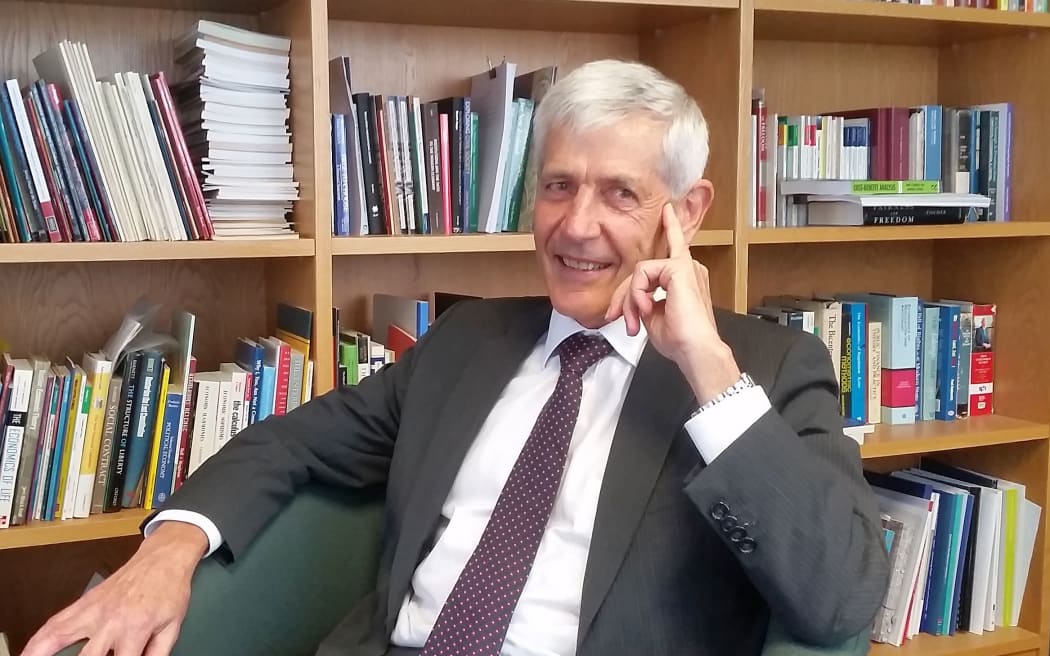 Man sits infrom of bookshelves