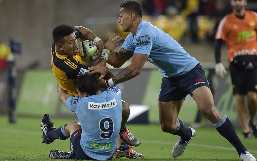 Ardie Savea is warpped up by Bernard Foley and Irael Folau.