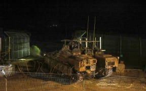 Israeli military armoured vehicles cross the fence to Syria near the Druze village of Majdal Shams in the Israel-annexed Golan Heights on December 8, 2024, after Islamist-led rebels declared that they have taken the Syrian capital in a lightning offensive, sending ousted president Bashar al-Assad fleeing and ending five decades of Baath rule in Syria. (Photo by Jalaa MAREY / AFP)