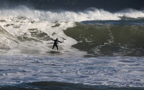 A surfer at Lyall Bay after a storm surge on 14 June 2015.