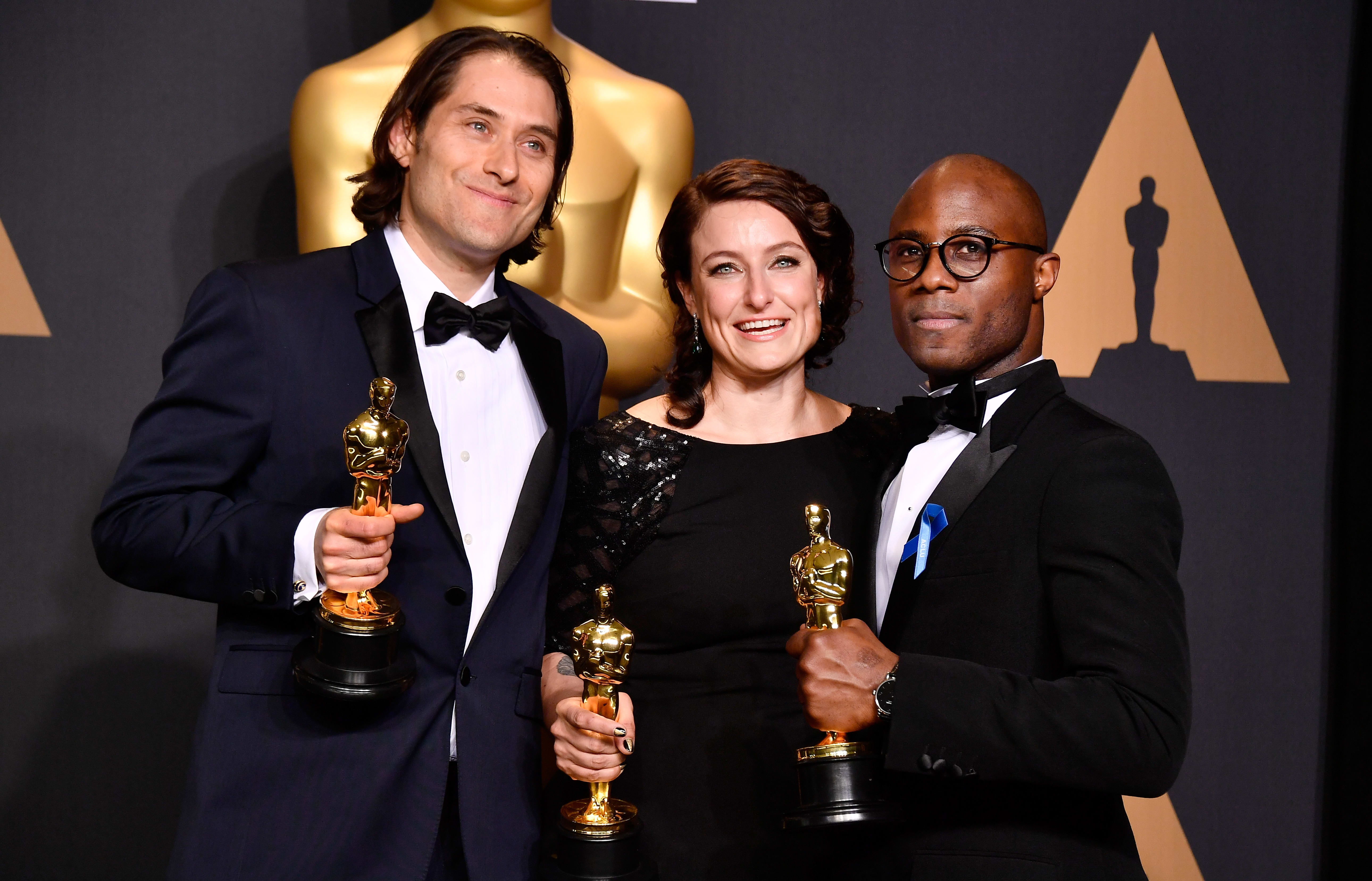 Producers Jeremy Kleiner, left, and Adele Romanski, winners of the award for Best Picture for 'Moonlight', pose with filmmaker Barry Jenkins.