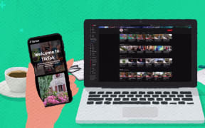 A laptop sits on a table next to a cup of coffee. The screen shows internet videos from TVNZ. A hand holds up a smartphone open to the app TikTok.